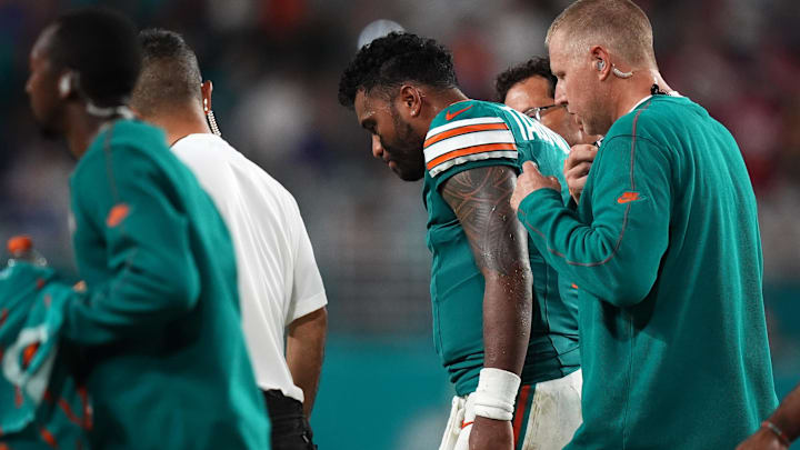 Miami Dolphins quarterback Tua Tagovailoa (1) walks off the field with training staff after sustaining a concussion during the second half against the Buffalo Bills at Hard Rock Stadium.