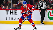 Mar 22, 2025; Montreal, Quebec, CAN; Montreal Canadiens center Nick Suzuki (14) plays the puck against the Colorado Avalanche in shootout at Bell Centre. Mandatory Credit: David Kirouac-Imagn Images