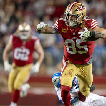 December 30, 2024; Santa Clara, California, USA; San Francisco 49ers tight end George Kittle (85) is tackled by Detroit Lions safety Ifeatu Melifonwu (6) during the fourth quarter at Levi's Stadium. Mandatory Credit: Kyle Terada-Imagn Images