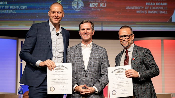Kentucky Governor Andy Beshear, center, posed for a photo onstage after giving Kentucky basketball coach Mark Pope and Louisville basketball coach Pat Kelsey the title of Kentucky Colonel at the 2024 Leadership Louisville Luncheon at the Kentucky International Convention Center in downtown Louisville on Wednesday, August 28, 2024.