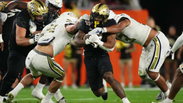 Dec 22, 2023; Tampa, FL, USA; UCF Knights running back RJ Harvey (7) runs the ball between Georgia Tech Yellow Jackets linebacker Kyle Efford (44) and linebacker Paul Moala (13) during the first half of the Gasparilla Bowl at Raymond James Stadium. Mandatory Credit: Jasen Vinlove-USA TODAY Sports