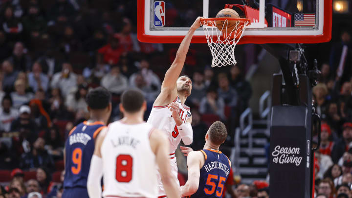 Dec 14, 2022; Chicago, Illinois, USA; Chicago Bulls center Nikola Vucevic (9) scores against New York Knicks center Isaiah Hartenstein (55) during the second half at United Center. 