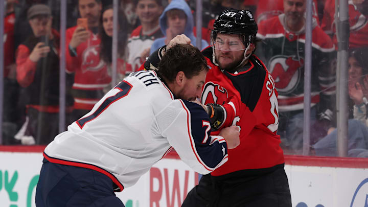 Blue Jackets defenseman Brendan Smith fights New Jersey Devils forward Paul Cotter