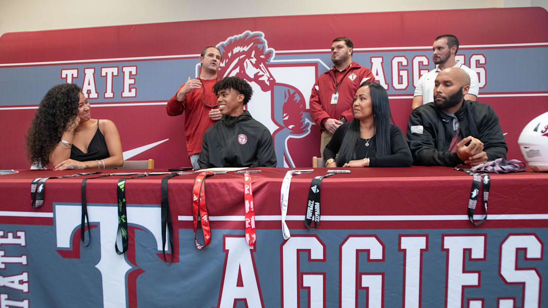 Christian Neptune signs his letter of intent to play football for the University of South Florida on National Signing Day