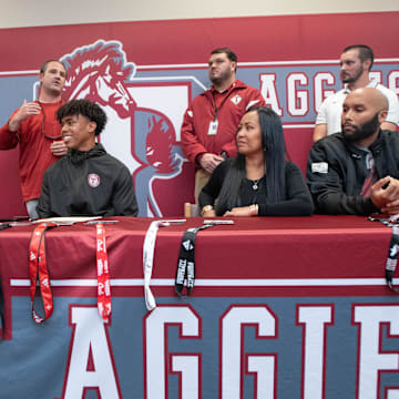 Christian Neptune signs his letter of intent to play football for the University of South Florida on National Signing Day