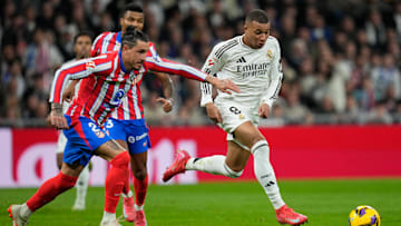 Kylian Mbappé and Jose Maria Gimenez tussle for the ball in a Madrid derby. 