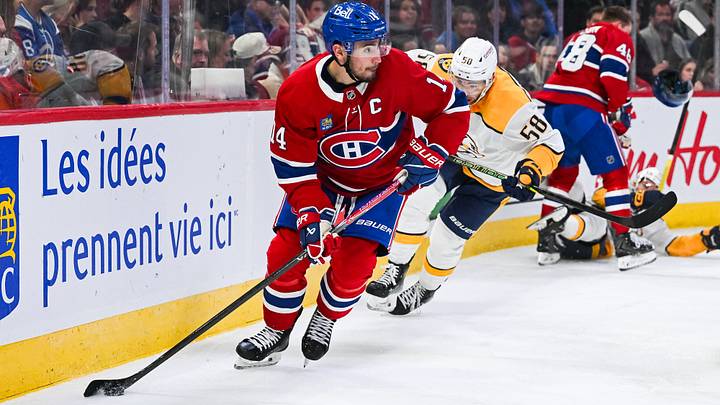 Oct 16, 2025; Montreal, Quebec, CAN; Montreal Canadiens center Nick Suzuki (14) plays the puck against Nashville Predators left wing Michael Bunting (58) during the third period at Bell Centre. Mandatory Credit: David Kirouac-Imagn Images
