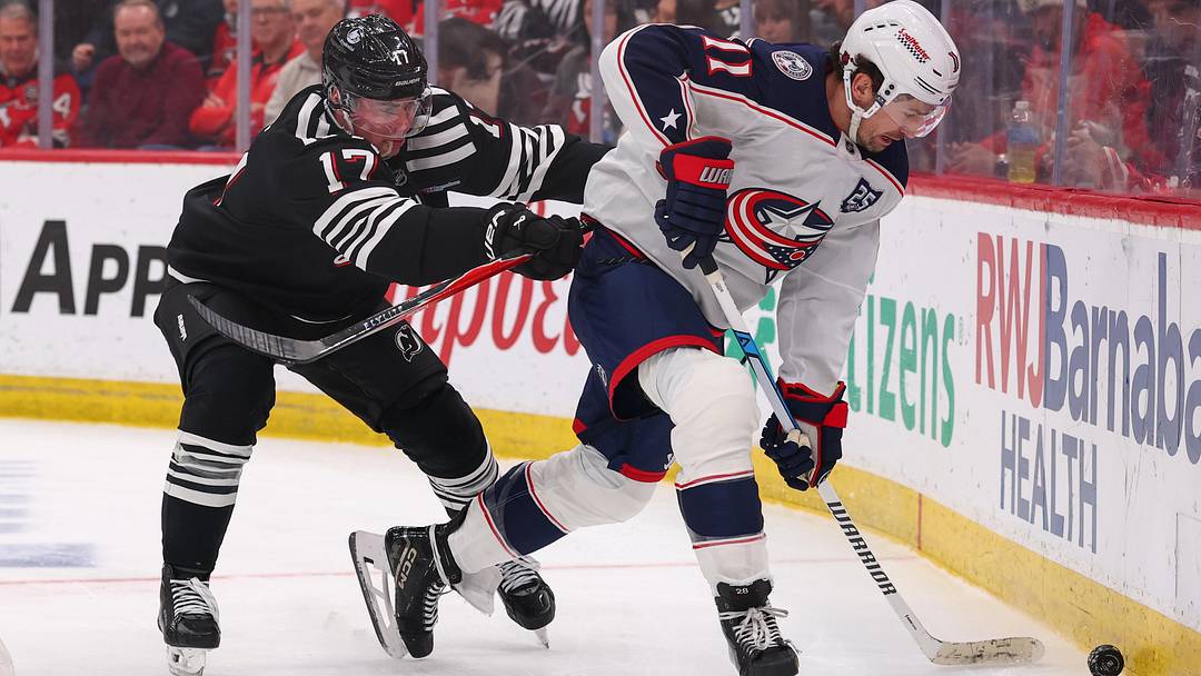 Feb 3, 2026; Newark, New Jersey, USA; Columbus Blue Jackets left wing Miles Wood (11) plays the puck as New Jersey Devils defenseman Simon Nemec (17) defends during the third period at Prudential Center. Mandatory Credit: Ed Mulholland-Imagn Images