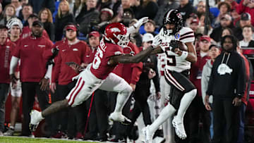 Texas Tech's Caleb Douglas (5) runs with the ball as Arkansas' Miguel Mitchell (16) attempts to tackle him during the AutoZone Liberty Bowl between Arkansas and Texas Tech in Memphis, Tenn., on Friday, December 27, 2024.