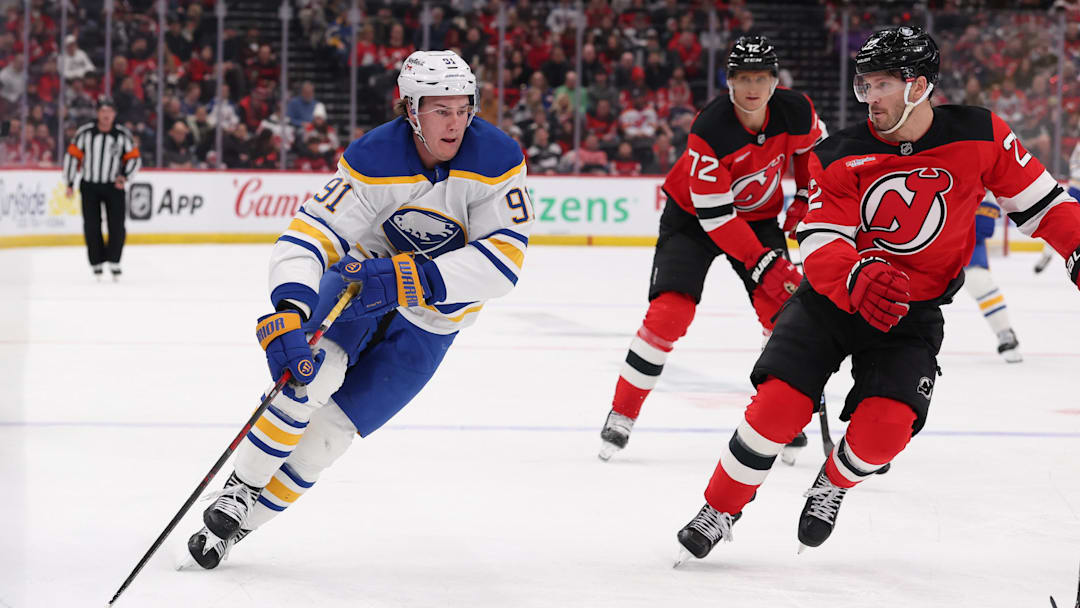 Feb 25, 2026; Newark, New Jersey, USA; Buffalo Sabres right wing Josh Doan (91) skates with the puck as New Jersey Devils defenseman Brett Pesce (22) defends during the first period at Prudential Center. Mandatory Credit: Ed Mulholland-Imagn Images