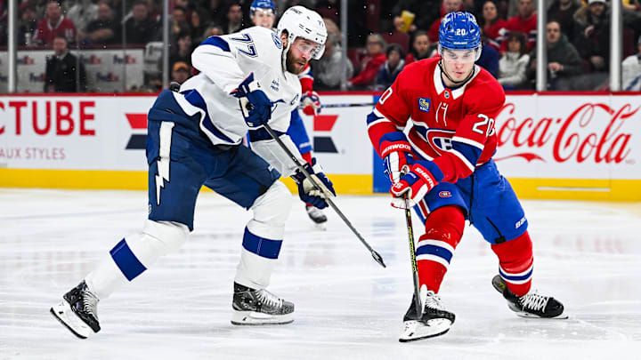 Jan 21, 2025; Montreal, Quebec, CAN; Montreal Canadiens left wing Juraj Slafkovsky (20) plays the puck against Tampa Bay Lightning defenseman Victor Hedman (77) during the third period at Bell Centre. Mandatory Credit: David Kirouac-Imagn Images