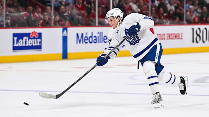 Sep 30, 2023; Montreal, Quebec, CAN; Toronto Maple Leafs center Ryan Tverberg (77) shoots the puck against the Montreal Canadiens during the third period at Bell Centre. Mandatory Credit: David Kirouac-Imagn Images