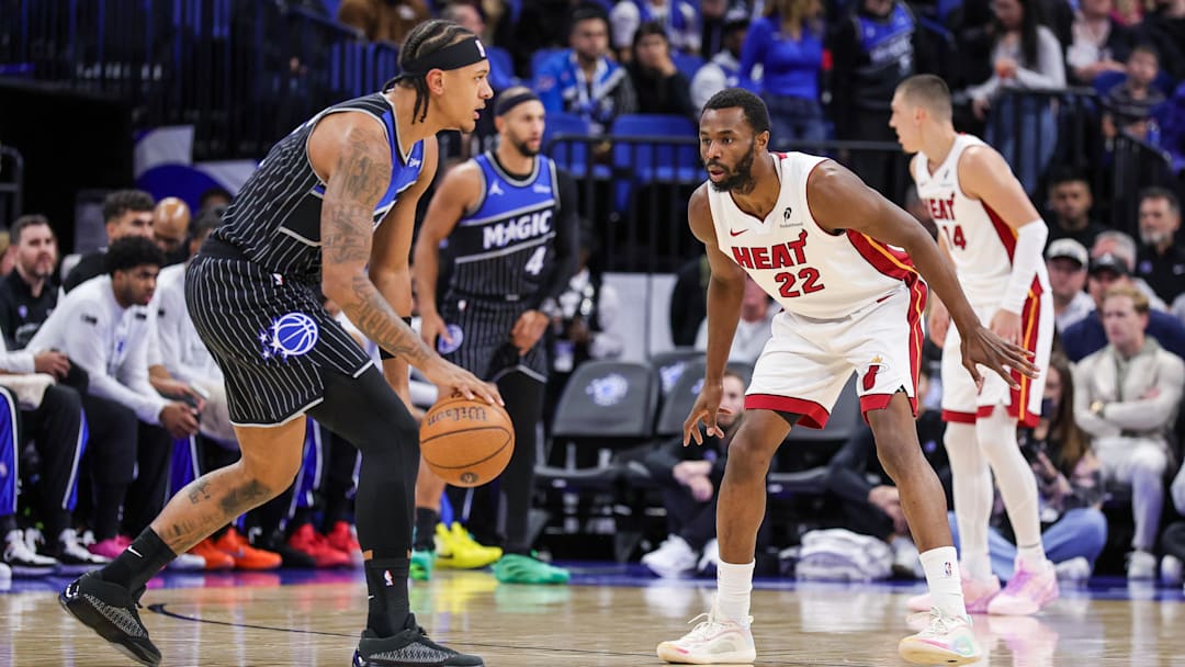 Dec 9, 2025; Orlando, Florida, USA; Miami Heat forward Andrew Wiggins (22) defends Orlando Magic forward Paolo Banchero (5) during the first quarter at Kia Center. Mandatory Credit: Mike Watters-Imagn Images