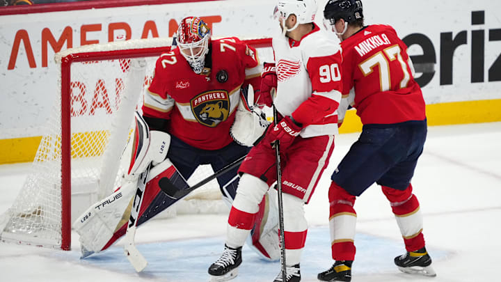 Jan 17, 2024; Sunrise, Florida, USA; Florida Panthers goaltender Sergei Bobrovsky (72) makes a save behind defenseman Niko Mikkola (77) and Detroit Red Wings center Joe Veleno (90) during the second period at Amerant Bank Arena. Mandatory Credit: Jasen Vinlove-Imagn Images