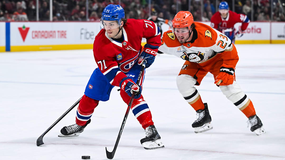 Dec 9, 2024; Montreal, Quebec, CAN; Montreal Canadiens center Jake Evans (71) plays the puck against Anaheim Ducks center Mason McTavish (23) during the second period at Bell Centre. Mandatory Credit: David Kirouac-Imagn Images