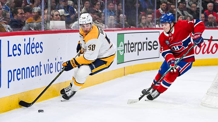 Nashville Predators left wing Michael Bunting (58) plays the puck against Montreal Canadiens right wing Cole Caufield (13): David Kirouac-Imagn Images