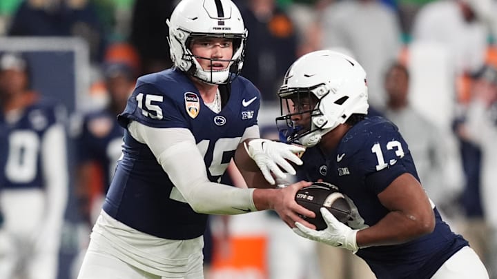 Penn State football quarterback Drew Allar handing the ball to running back Kaytron Allen