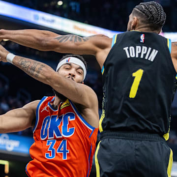 Apr 5, 2024; Indianapolis, Indiana, USA; Oklahoma City Thunder forward Kenrich Williams (34) rebounds the ball over Indiana Pacers forward Obi Toppin (1) in the first half at Gainbridge Fieldhouse. Mandatory Credit: Trevor Ruszkowski-Imagn Images