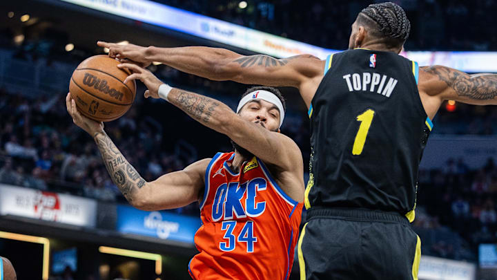 Apr 5, 2024; Indianapolis, Indiana, USA; Oklahoma City Thunder forward Kenrich Williams (34) rebounds the ball over Indiana Pacers forward Obi Toppin (1) in the first half at Gainbridge Fieldhouse. Mandatory Credit: Trevor Ruszkowski-Imagn Images