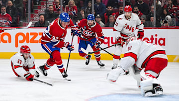 Apr 16, 2025; Montreal, Quebec, CAN; Montreal Canadiens right wing Patrik Laine (92) plays the puck against Carolina Hurricanes defenseman Domenick Fensore (89) in the first period at Bell Centre. Mandatory Credit: David Kirouac-Imagn Images