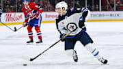 Jan 28, 2025; Montreal, Quebec, CAN; Winnipeg Jets defenseman Neal Pionk (4) plays the puck against the Montreal Canadiens during the third period at Bell Centre. Mandatory Credit: David Kirouac-Imagn Images