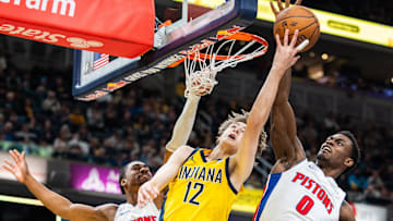 Nov 29, 2024; Indianapolis, Indiana, USA; Indiana Pacers forward Johnny Furphy (12) shoots the ball while Detroit Pistons guard Jaden Ivey (23) and  center Jalen Duren (0) defend: Trevor Ruszkowski-Imagn Images