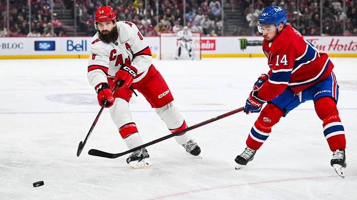 Apr 16, 2025; Montreal, Quebec, CAN; Carolina Hurricanes defenseman Brent Burns (8) gets rid of the puck as Montreal Canadiens center Nick Suzuki (14) closes in during the second period at Bell Centre. Mandatory Credit: David Kirouac-Imagn Images