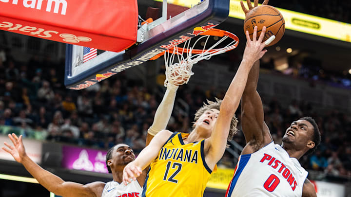 Nov 29, 2024; Indianapolis, Indiana, USA; Indiana Pacers forward Johnny Furphy (12) shoots the ball while Detroit Pistons guard Jaden Ivey (23) and  center Jalen Duren (0) defend: Trevor Ruszkowski-Imagn Images