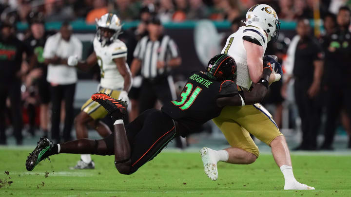 Oct 7, 2023; Miami Gardens, Florida, USA; Miami Hurricanes linebacker Wesley Bissainthe (31) brings down Georgia Tech Yellow Jackets tight end Luke Benson (81) in the first half at Hard Rock Stadium. Mandatory Credit: Jasen Vinlove-USA TODAY Sports