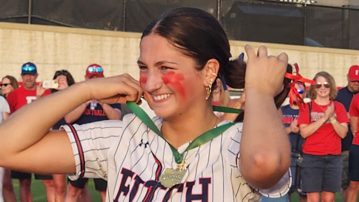 Austintown-Fitch softball catcher Kylie Folkwein puts on her medal after winning the 2025 regional final. Folkwein was one of five catchers voted to the 2025 High School On SI Ohio fan-voted all-star team.