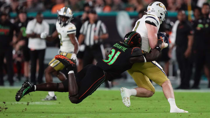 Oct 7, 2023; Miami Gardens, Florida, USA; Miami Hurricanes linebacker Wesley Bissainthe (31) brings down Georgia Tech Yellow Jackets tight end Luke Benson (81) in the first half at Hard Rock Stadium. Mandatory Credit: Jasen Vinlove-USA TODAY Sports