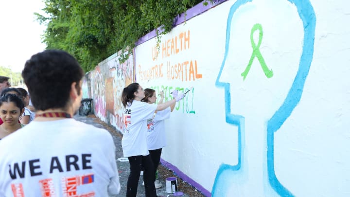 People with the UF Health Psychiatric Hospital paint a mural to raise awareness for Mental Health Month, at the 34th Street Wall in Gainesville FL. May 19, 2022. May is National Mental Health Awareness Month and the UF Health Psychiatric Hospital is raising awareness with this mural.  [Brad McClenny/The Gainesville Sun]

Flgai 051922 Mentalhealthmural 03