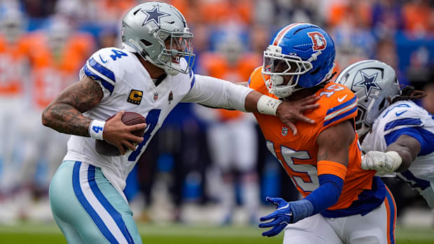 Dallas Cowboys quarterback Dak Prescott (4) fends off Denver Broncos linebacker Nik Bonitto (15).