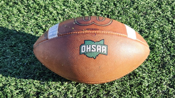 A football with the OHSAA logo sits on the field.