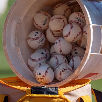 Feb 18, 2024; Peoria, AZ, USA; A general view as a coach for the San Diego Padres pours a bucket of baseballs into the to go bag during a workout day at Peoria Sports Complex. Mandatory Credit: Allan Henry-Imagn Images