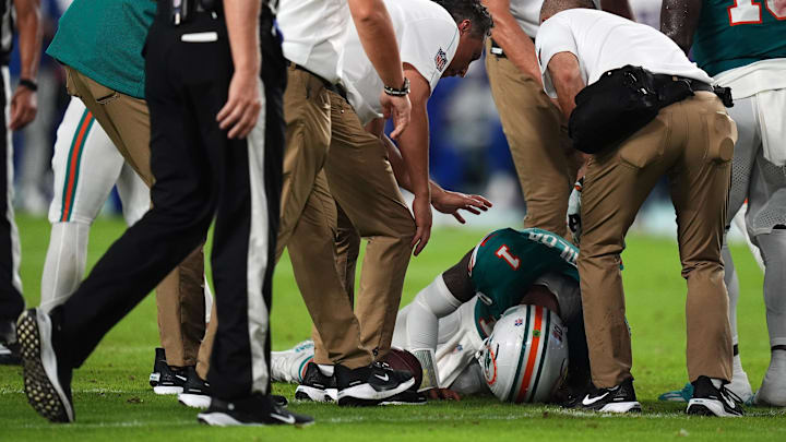 Sep 12, 2024; Miami Gardens, Florida, USA; A members of the Miami Dolphins training staff attend to quarterback Tua Tagovailoa (1) after an apparent injury during the second half against the Buffalo Bills at Hard Rock Stadium. Mandatory Credit: Jasen Vinlove-Imagn Images