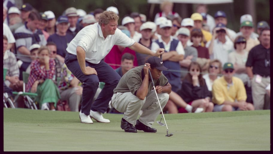 Tiger Woods lines up putt with Colin Montgomerie behind him at the Augusta National Golf Course during the 1997 Masters.