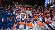 The Illinois football team gathers on the snow mounds inside Gies Memorial Stadium after its 20-13 win over Northwestern on Saturday in its season finale in Champaign, Illinois.