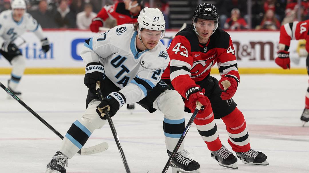 Utah Mammoth center Barrett Hayton (27) skates with the puck as New Jersey Devils defenseman Luke Hughes (43) during the first period at Prudential Center. Mandatory Credit: Ed Mulholland-Imagn Images