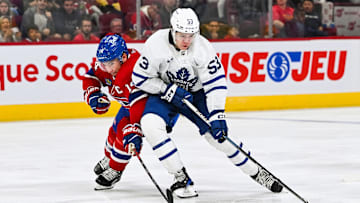 Sep 30, 2023; Montreal, Quebec, CAN; Toronto Maple Leafs right wing Easton Cowan (53) plays the puck against Montreal Canadiens center Nick Suzuki (14) during the third period at Bell Centre. Mandatory Credit: David Kirouac-Imagn Images