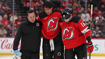 New Jersey Devils defenseman Brenden Dillon (5) is helped off the ice after a fight. Mandatory Credit: Ed Mulholland-Imagn Images