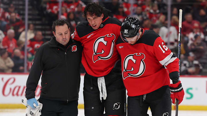 New Jersey Devils defenseman Brenden Dillon (5) is helped off the ice after a fight. Mandatory Credit: Ed Mulholland-Imagn Images