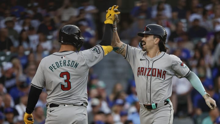 Jul 20, 2024; Chicago, Illinois, USA; Arizona Diamondbacks outfielder Corbin Carroll (7) celebrates with designated hitter Joc Pederson (3) after hitting a two-run home run against the Chicago Cubs during the fifth inning at Wrigley Field. Mandatory Credit: Kamil Krzaczynski-USA TODAY Sports