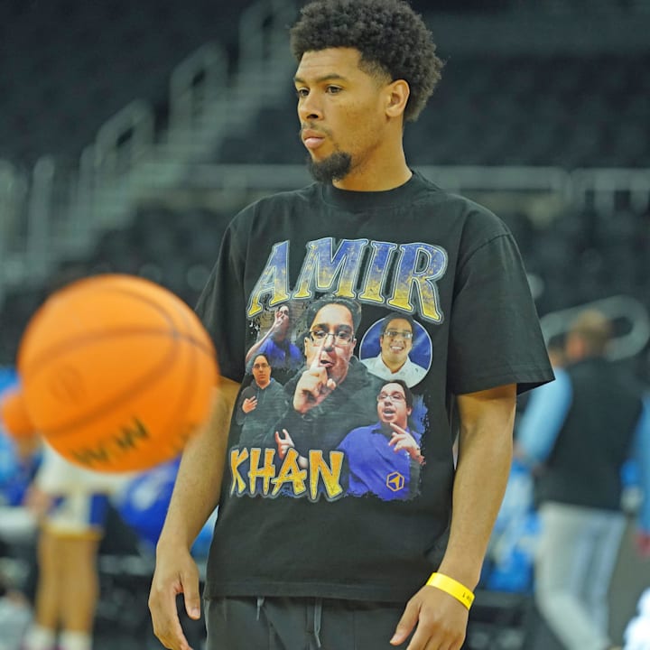 A member of the McNeese State men's basketball team wears a t-shirt with the likeness of team manager Amir Khan.