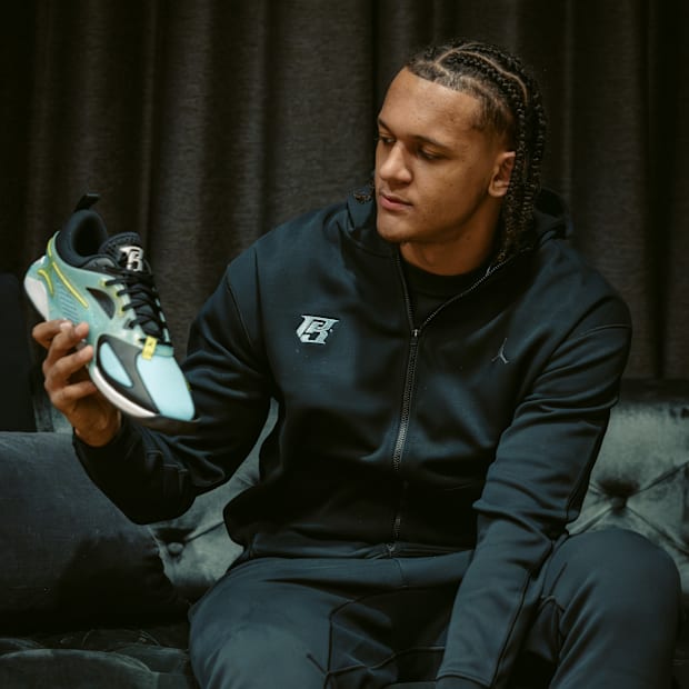 Paolo Banchero holds his blue sneakers.