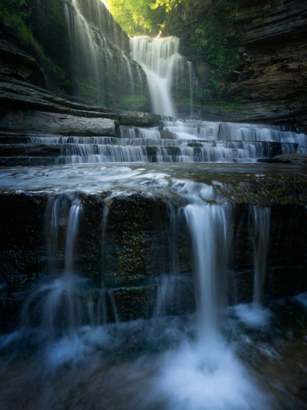 An incredible waterfall with several levels shining in the dark.