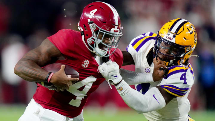 Nov 4, 2023; Tuscaloosa, Alabama, USA; Alabama Crimson Tide quarterback Jalen Milroe (4) scrambles up the field against LSU Tigers linebacker Harold Perkins Jr. (4)  during the second half at Bryant-Denny Stadium. Alabama Crimson Tide defeated the LSU Tigers 42-28. Mandatory Credit: John David Mercer-USA TODAY Sports