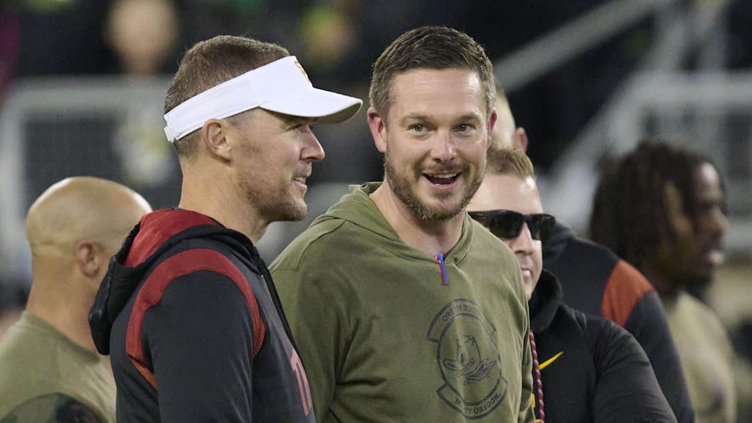 Nov 11, 2023; Eugene, Oregon, USA; USC Trojans head coach Lincoln Riley, left, and Oregon Ducks head coach Dan Lanning talk before a game at Autzen Stadium. Mandatory Credit: Troy Wayrynen-Imagn Images