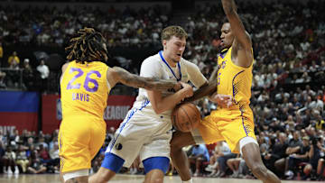 Jul 10, 2025; Las Vegas, NV, USA; Dallas Mavericks forward Cooper Flagg (32) dribbles against Los Angeles Lakers guard RJ Davis (26) and guard DaJaun Gordon (45) in the first quarter of their game at Thomas & Mack Center. Mandatory Credit: Candice Ward-Imagn Images