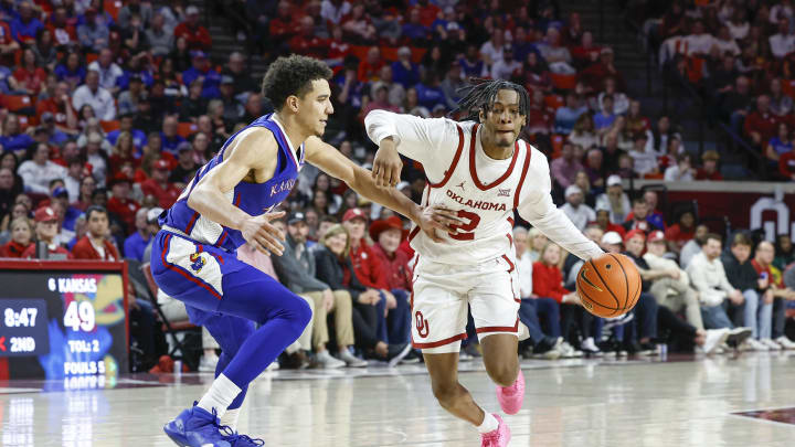 Feb 17, 2024; Norman, Oklahoma, USA; Oklahoma Sooners guard Javian McCollum (2) drives to the basket around Kansas Jayhawks guard Kevin McCullar Jr. (15)  during the second half at Lloyd Noble Center. Mandatory Credit: Alonzo Adams-USA TODAY Sports